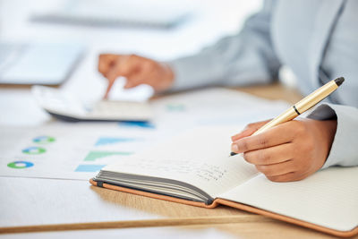 Midsection of businessman working on table