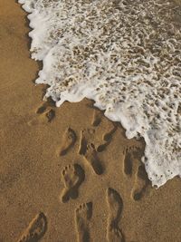 High angle view of footprints on sand at beach