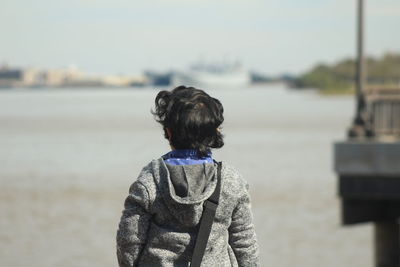 Rear view of boy standing at beach