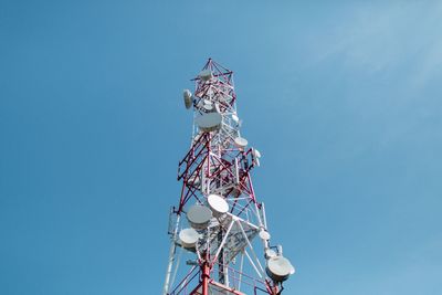 Low angle view of communications tower against blue sky