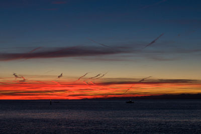 Scenic view of sea against dramatic sky during sunset