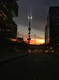 Illuminated street against sky at night