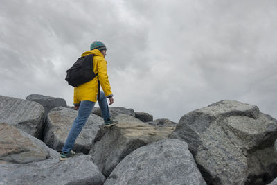 Woman hiker climbing over rocks