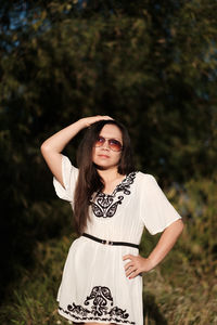 Portrait of beautiful young woman standing against plants