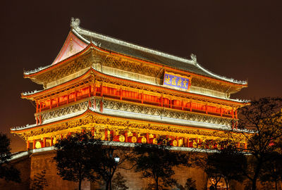 Low angle view of illuminated building against sky at night