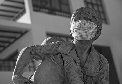 Statue of afraid boy wearing covid mask