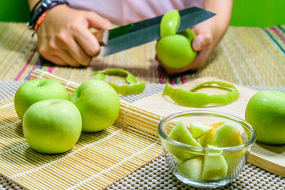 Midsection of woman holding apple on table