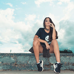 Portrait of woman sitting against wall