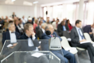 Close-up of microphone with business people sitting in background during seminar