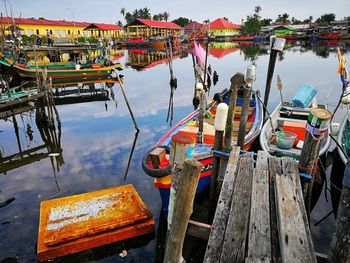 Fishing boats moored in lake against sky