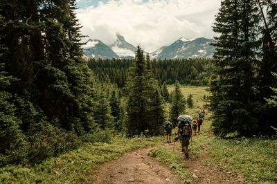 People walking on pathway against mt assiniboine