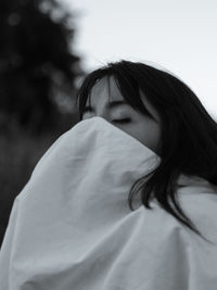 Portrait of woman standing against blurred background