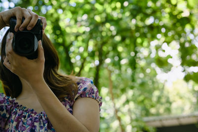 Young woman using camera with beautiful bokeh , learning , travel and recreation concept