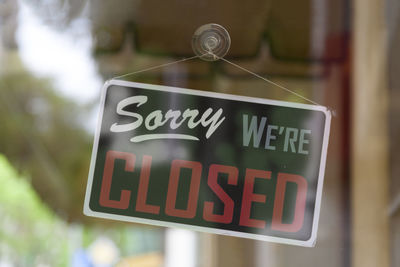 Close-up on an closed sign in the window of a shop saying sorry, we're closed.