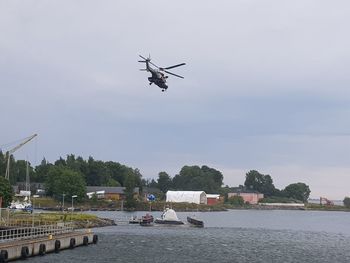 Airplane flying over river against sky