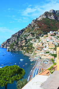 Scenic view of sea and mountains against blue sky