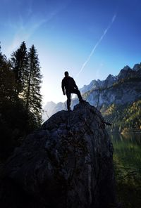 Silhouette man standing on rock against mountain