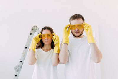 Happy smiling married couple engaged in renovation repair in the room of the house preparing to move