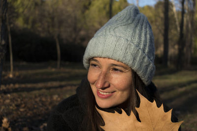 Close-up of young woman holding leaf