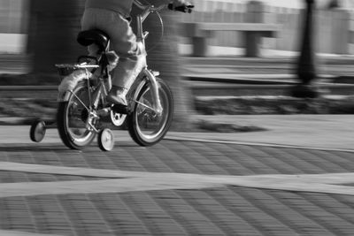 Low section of man with bicycle on road