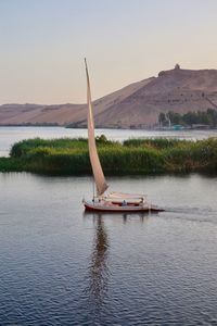 Sailboat in lake against sky