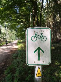 Information sign by road against trees