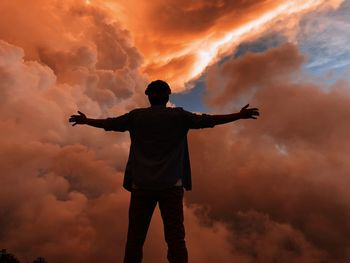 Rear view of silhouette man standing against sky during sunset