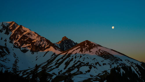 Scenic view of snowcapped mountains against sky at night