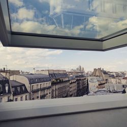 Cityscape against sky seen through window