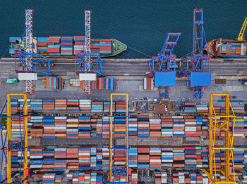 High angle view of cranes on pier against blue sky