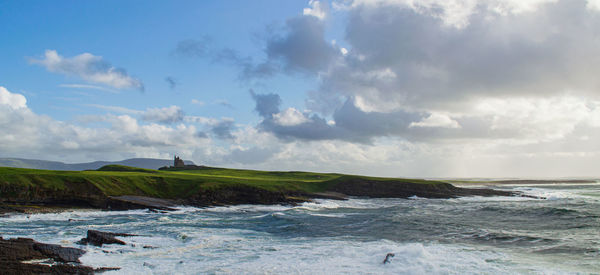 Castle on the cliff with the ocean waves crushing on the shore