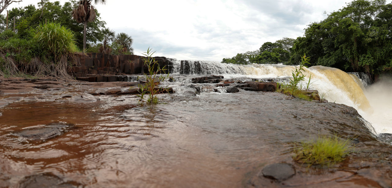 SCENIC VIEW OF WATERFALL AGAINST SKY