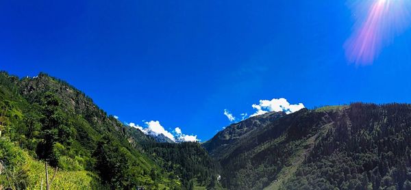 Scenic view of mountains against blue sky