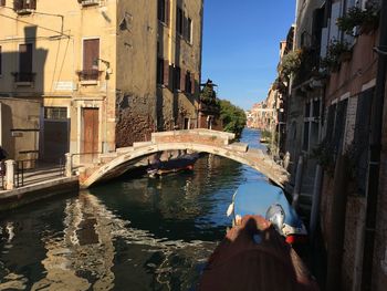 Bridge over canal amidst buildings in city