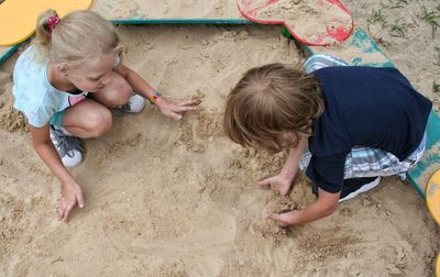 High angle view of girl playing with sand