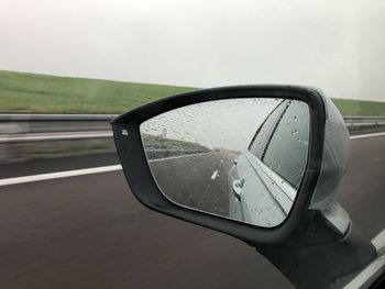 Close-up of wet side-view mirror
