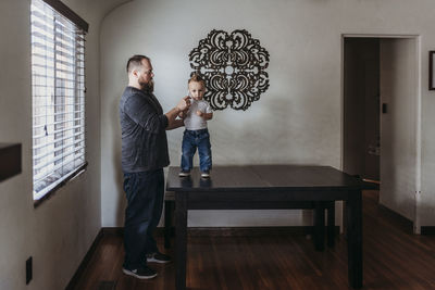 Father taking young sons temperature at home during isolation