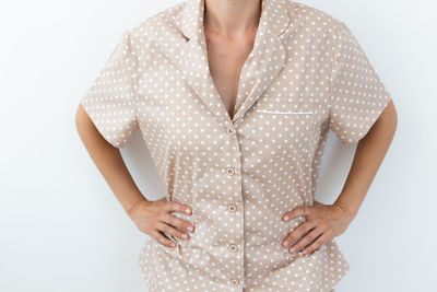 Midsection of woman standing against white background