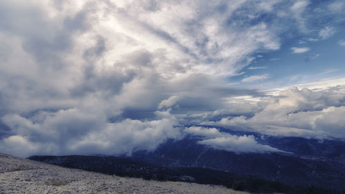 Scenic view of mountains against cloudy sky