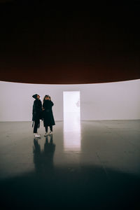 Silhouette people standing on floor against sky