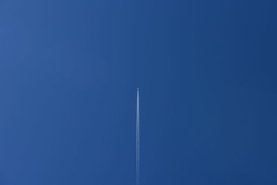 Low angle view of vapor trail against blue sky