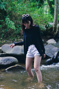 Portrait of young woman standing in water