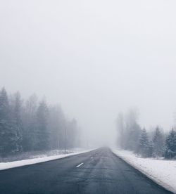 Road amidst trees during winter