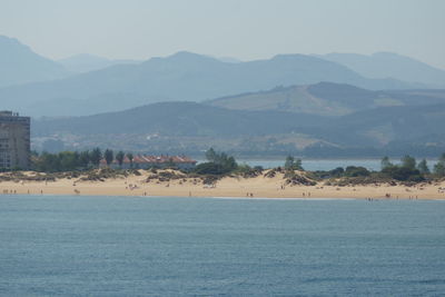 Scenic view of sea and mountains against sky