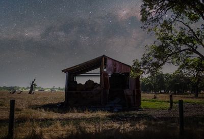 Abandoned built structure on landscape against sky at night