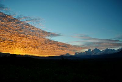 Scenic view of silhouette mountains against sky at sunset