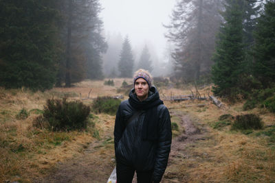 Portrait of smiling woman standing in forest