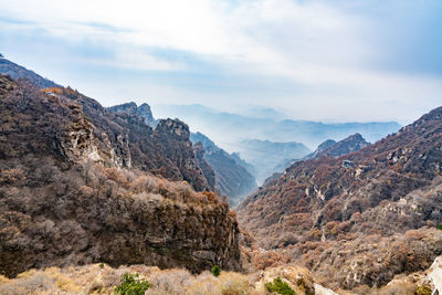 View of rocky mountains against cloudy sky