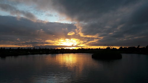 Scenic view of dramatic sky over river during sunset