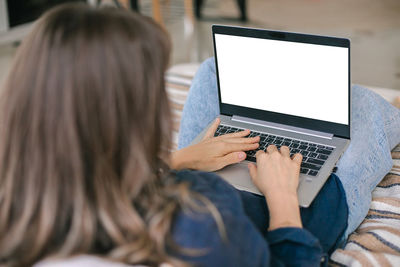 Woman typing on laptop at home